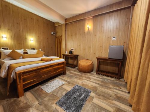 een slaapkamer met een bed en een televisie. bij Tea Brook Lodge Ella in Ella