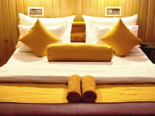 een groot bed met 2 kussens en 2 dekens bij Tea Brook Lodge Ella in Ella