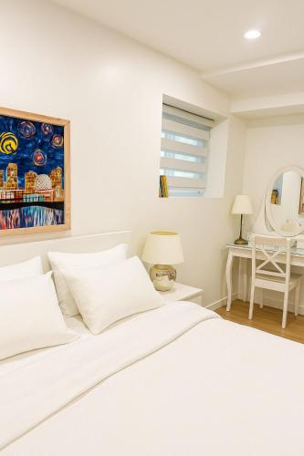 a white bedroom with a bed and a table at Deep Cove holiday in North Vancouver