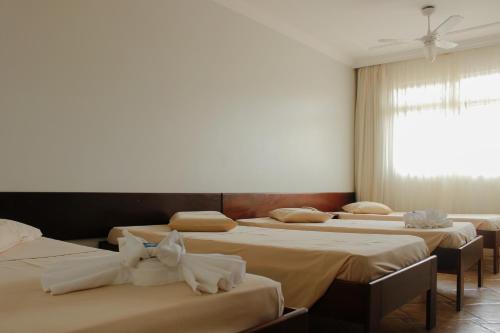 a group of four beds in a room at Cracco Park Hotel in Curitiba