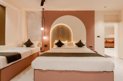 a bedroom with two beds and an arched window at Legacy Inn, Mysore in Mysore