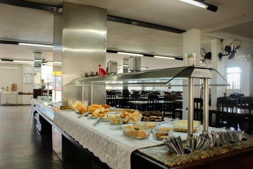 una cocina con una barra con comida. en Cracco Park Hotel en Curitiba