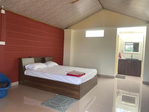 a bedroom with a bed with a red wall at Anjanadri Lakeview Gardens - Sapthashree Nivasa in Hosūr