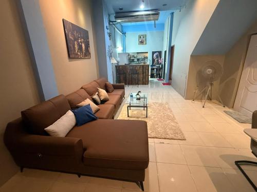 a living room with a brown couch and a table at Alura Hostel in Kata Beach