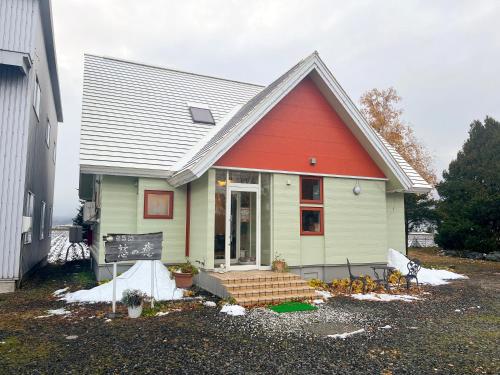 a small house with a red roof at Meguminoyu in Furano