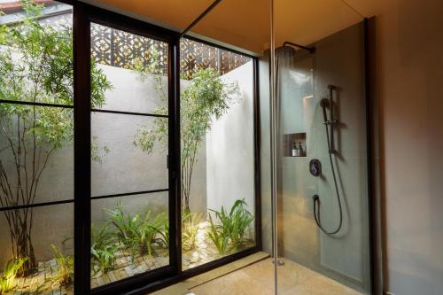 Greenpark Resort and Spa, Madikeri في ماديكيري: حمام مع دش ونافذة كبيرة