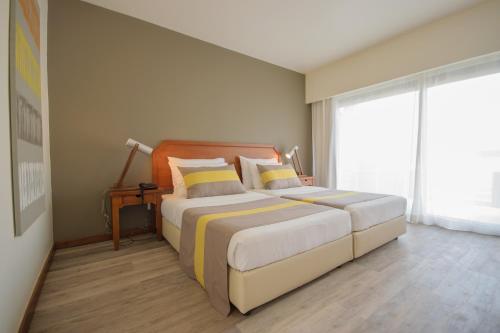 a bedroom with a large bed and a large window at Oasis Belorizonte in Santa Maria