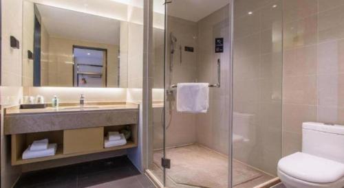 een badkamer met douche, wastafel en toilet bij City Comfort Inn Changning Wangchao in Changning