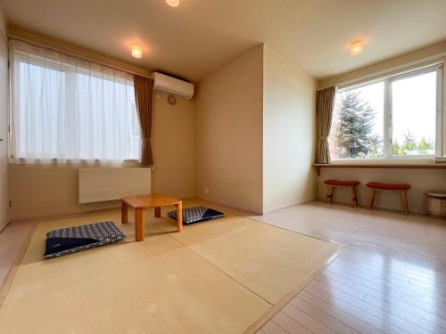 a living room with two red chairs and a table at Meguminoyu in Furano