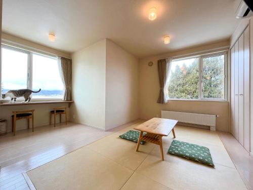 a living room with a cat sitting in the window at Meguminoyu in Furano
