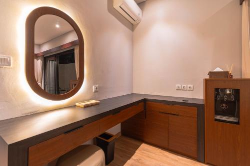 a bathroom with a mirror and a sink at Jiwandari House Bali in Darmasaba