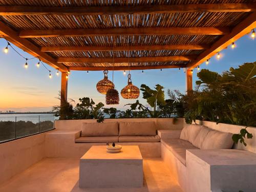 a patio with a couch and a table and lights at Exclusive apt with private rooftop & amazing views in Cancún