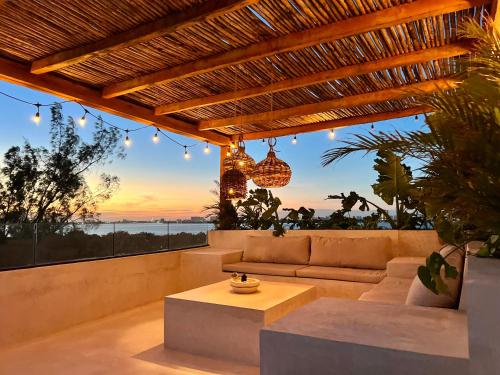 an outdoor living room with a couch and a table at Exclusive apt with private rooftop & amazing views in Cancún