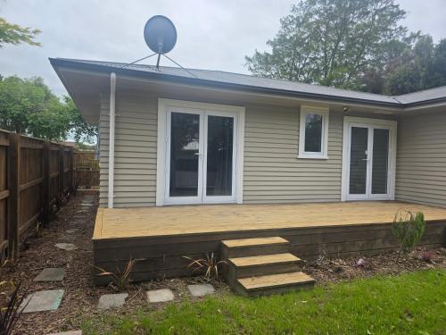 a house with a wooden deck in the yard at Modern, House in central Palmerston North in Palmerston North