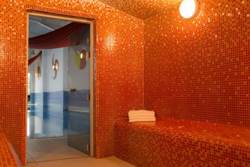 a red tiled bathroom with a shower and a mirror at Talbot Hotel Clonmel in Clonmel