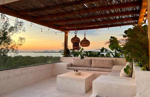 a patio with a couch and a view of the ocean at Exclusive apt with private rooftop & amazing views in Cancún