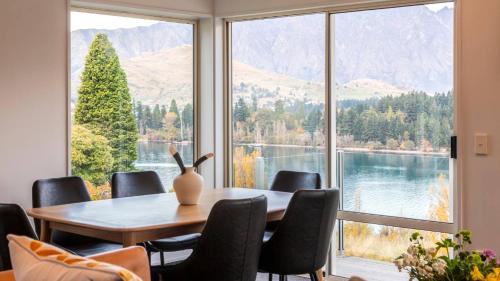 a dining room with a table and chairs and a large window at Ruru Retreat- Free Parking- Hot Tub- Walk To Town in Queenstown