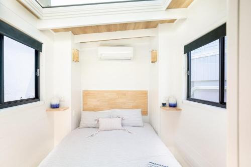 a small bedroom with a bed in a tiny house at Tiny Home in the heart of Broadbeach-River Views! in Gold Coast