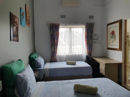 une chambre avec deux lits et une fenêtre dans l'établissement Ntoliwa Bed and Breakfast, à Suits Me