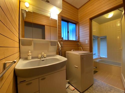 a bathroom with a sink and a toilet and a tub at 花の街660 Tsumagoi Private House with Parking & BBQ in Tsumagoi