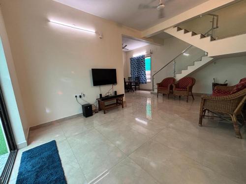 a living room with a flat screen tv and chairs at VINTAGE VISTA RESORTs in Chennai