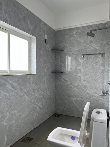 Un baño con inodoro y ventana. en The Ashvem Horizon, en Mandrem