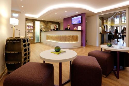 a lobby with two tables and a counter in a store at Pfalzhotel Asselheim in Asselheim