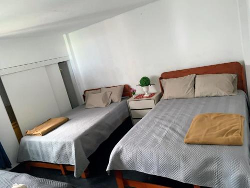 a bedroom with two beds and a night stand at HOSPEDAJE don VICTOR in Chancayllo