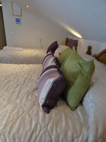 a bed with pillows laying on top of it at Meadowcroft Guest House in Windermere