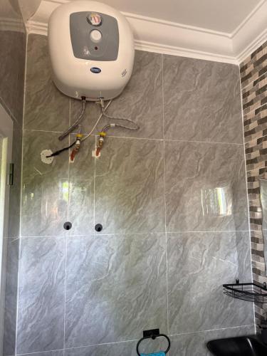 a bathroom with a tiled wall with a ceiling at My Dream in Manduar