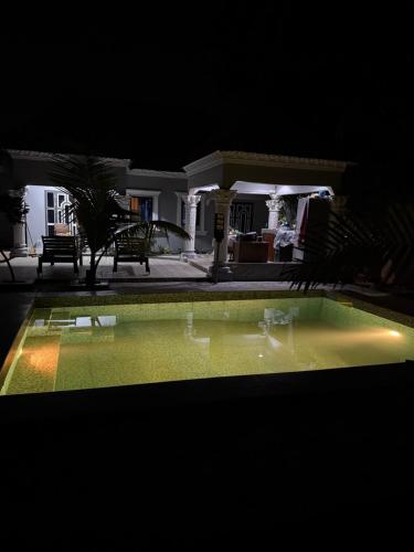 a swimming pool at night with a house in the background at My Dream in Manduar