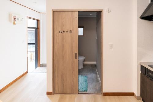 下田市にあるNODE Shimodaのバスルーム(木製のドア付)が備わります。