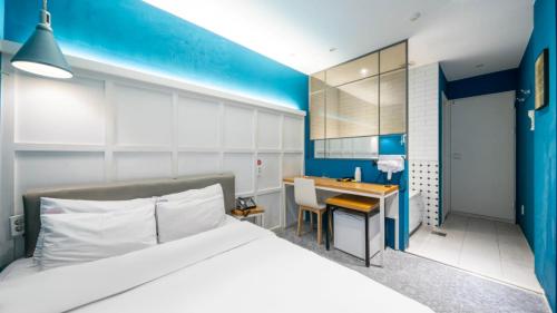 a bedroom with a large bed and a desk at NU Hotel in Cheonan