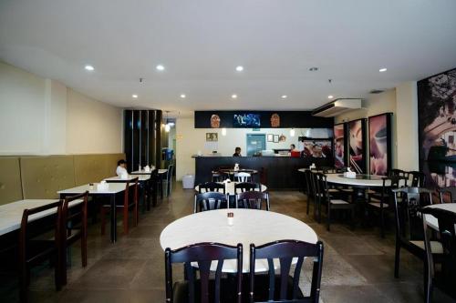 a dining room with tables and chairs in a restaurant at Traders Inn Brunei in Kampong Mata Mata