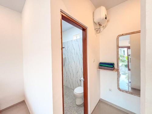 une salle de bain avec toilettes et miroir dans l'établissement Oemah Maha, à Tanah Lot