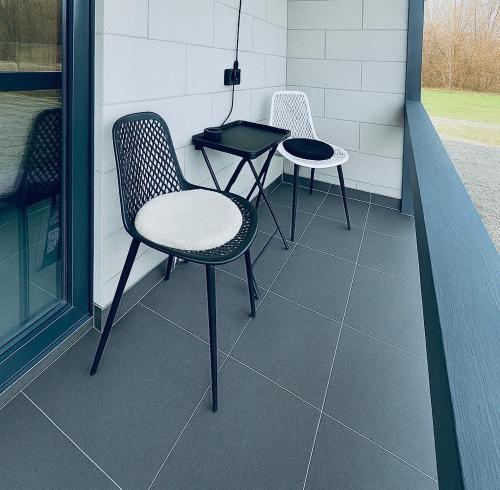 two chairs and a table on a porch at Secret Forest Avrig By Erwin in Avrig