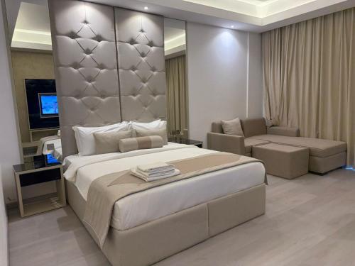 a bedroom with a large bed and a living room at Dibba Sea View Hotel by AMA Pro in Dibba