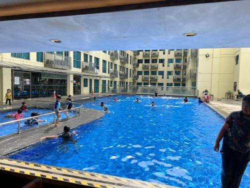 a group of people swimming in a swimming pool at VY STUDIO ROOM SCSP Ming Garden Kota Kinabalu in Kota Kinabalu