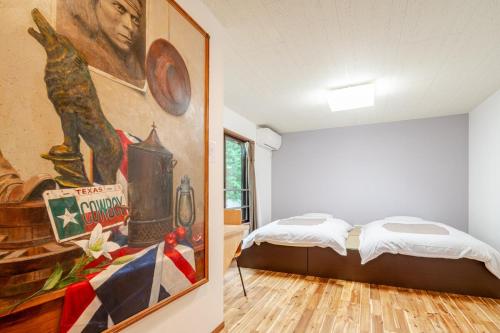 a bedroom with a bed and a painting on the wall at Hakone Villa with your private hot spring! in Hakone