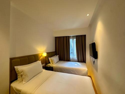 吉隆坡D Loft Hotel的一间有两张床和一台电视的酒店房间