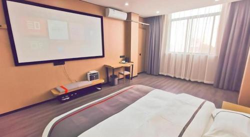 a room with a large screen in a hotel room at Thank Inn Plus Hotel Jiangyin University in Wuxi