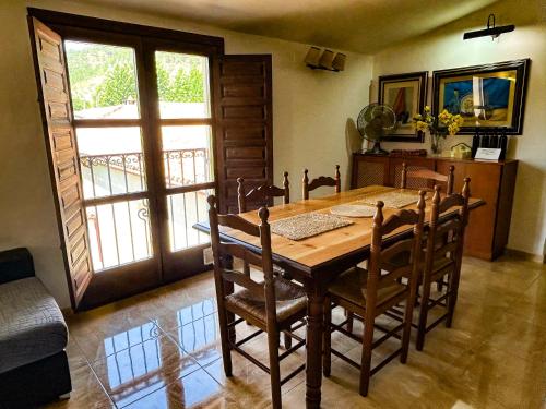 een eetkamer met een houten tafel en stoelen bij Puerta del Arco in Riópar