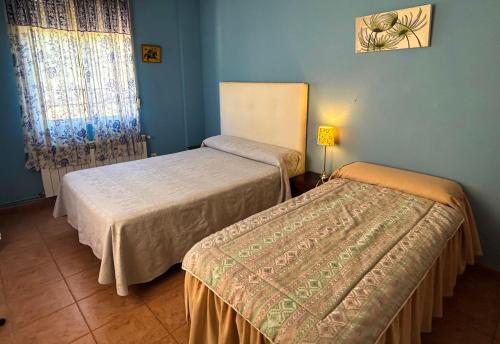 twee bedden in een kamer met blauwe muren bij Puerta del Arco in Riópar
