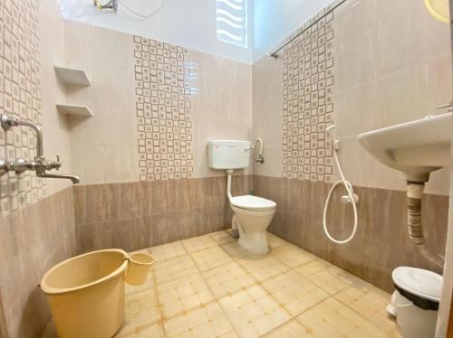 a bathroom with a toilet and a sink at La Paradise Residency - TIE Hotels & Resorts in Puducherry