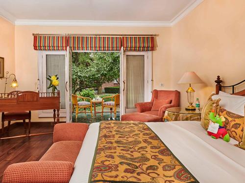 Un dormitorio con una cama y una sala de estar. en The LaLit Grand Palace Srinagar, en Srinagar