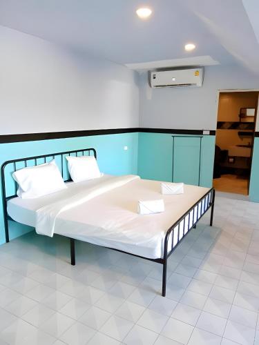 a bed with white sheets and pillows in a room at XX Mitr Inn - ภูเก็ต เมืองเก่า Phuket Old Town 2 in Phuket
