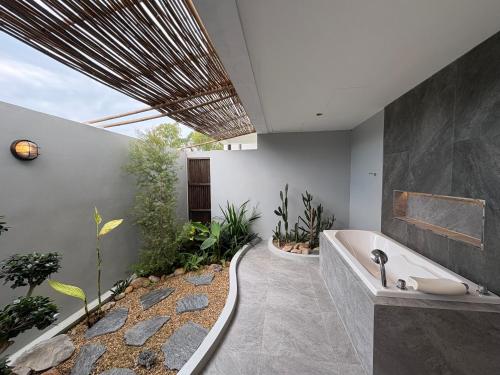 Ban Nong ChaengにあるMonte Viento Khao Yaiのバスルーム(バスタブ、植物付)
