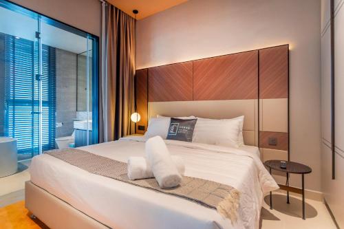 a bedroom with a large white bed and a window at Antara Genting Highlands by COBNB - near Link Bridge in Genting Highlands