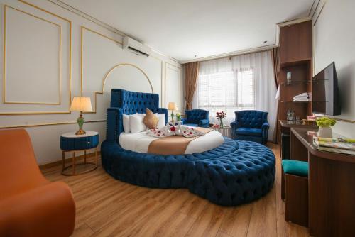 a hotel room with a bed and a blue ottoman at Royal Hotel & Spa in Ðồng Ky