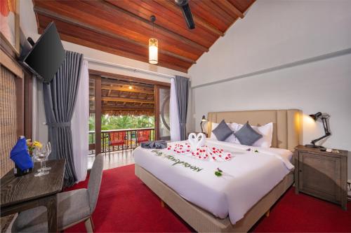 een slaapkamer met een groot wit bed en een balkon bij Hoianbang Beach Front Villa and Restaurant in An Bàn (2)